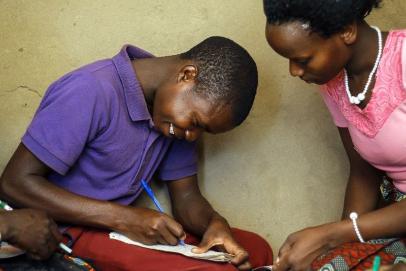 Boy Writing With Woman