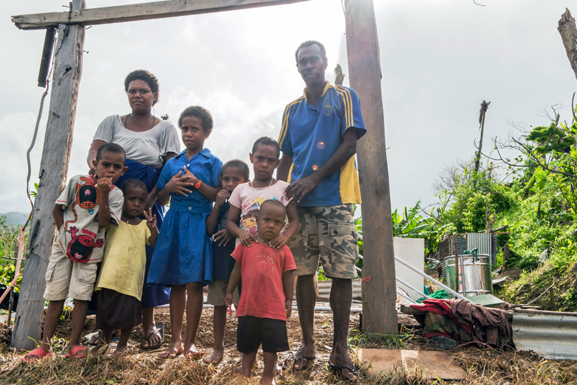 Family in Fiji outside house destroyed by cyclone